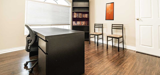 Private counseling room with desk, chairs, and bookshelf