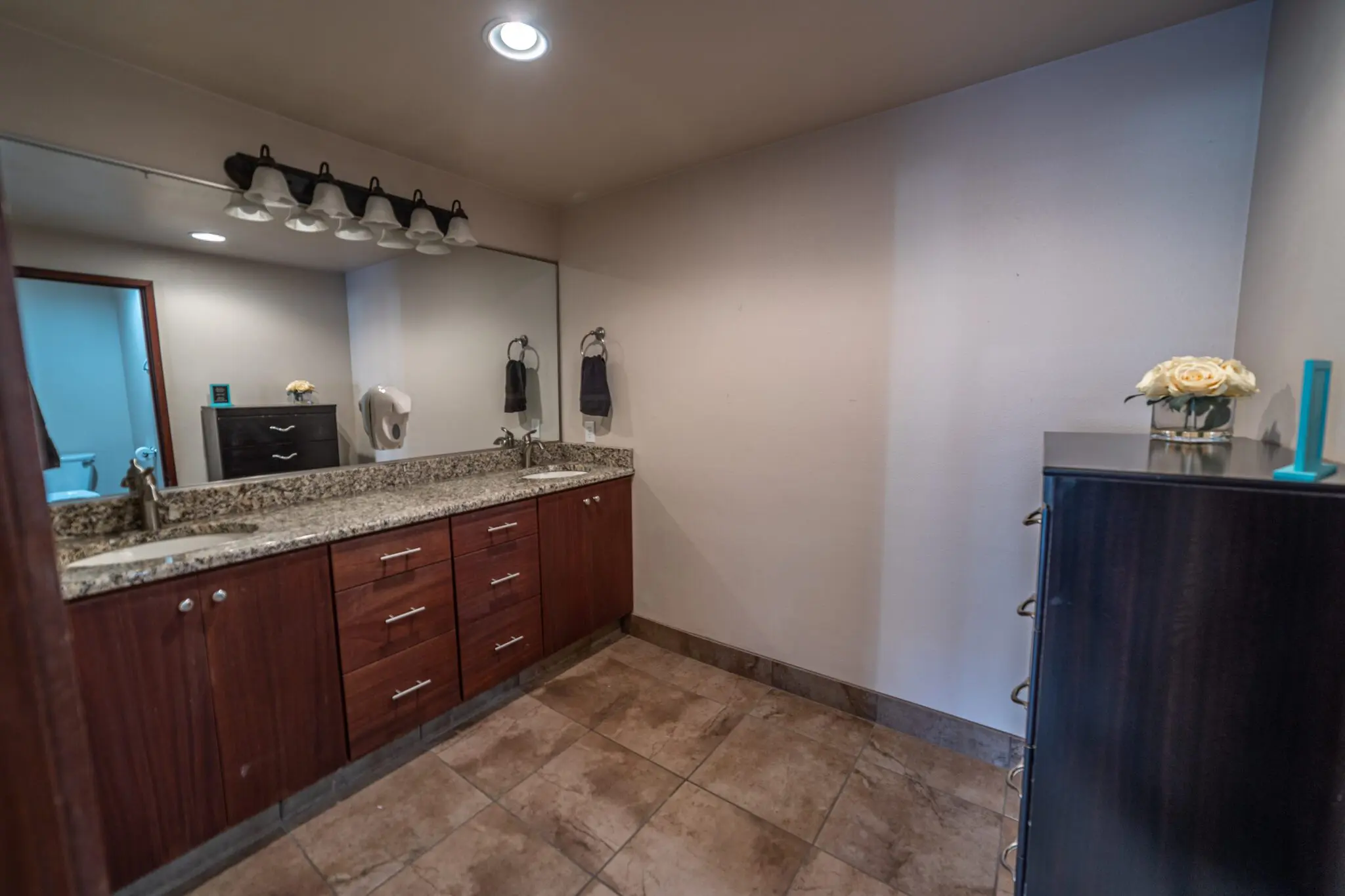 Shared bathroom with sink, mirror, and storage