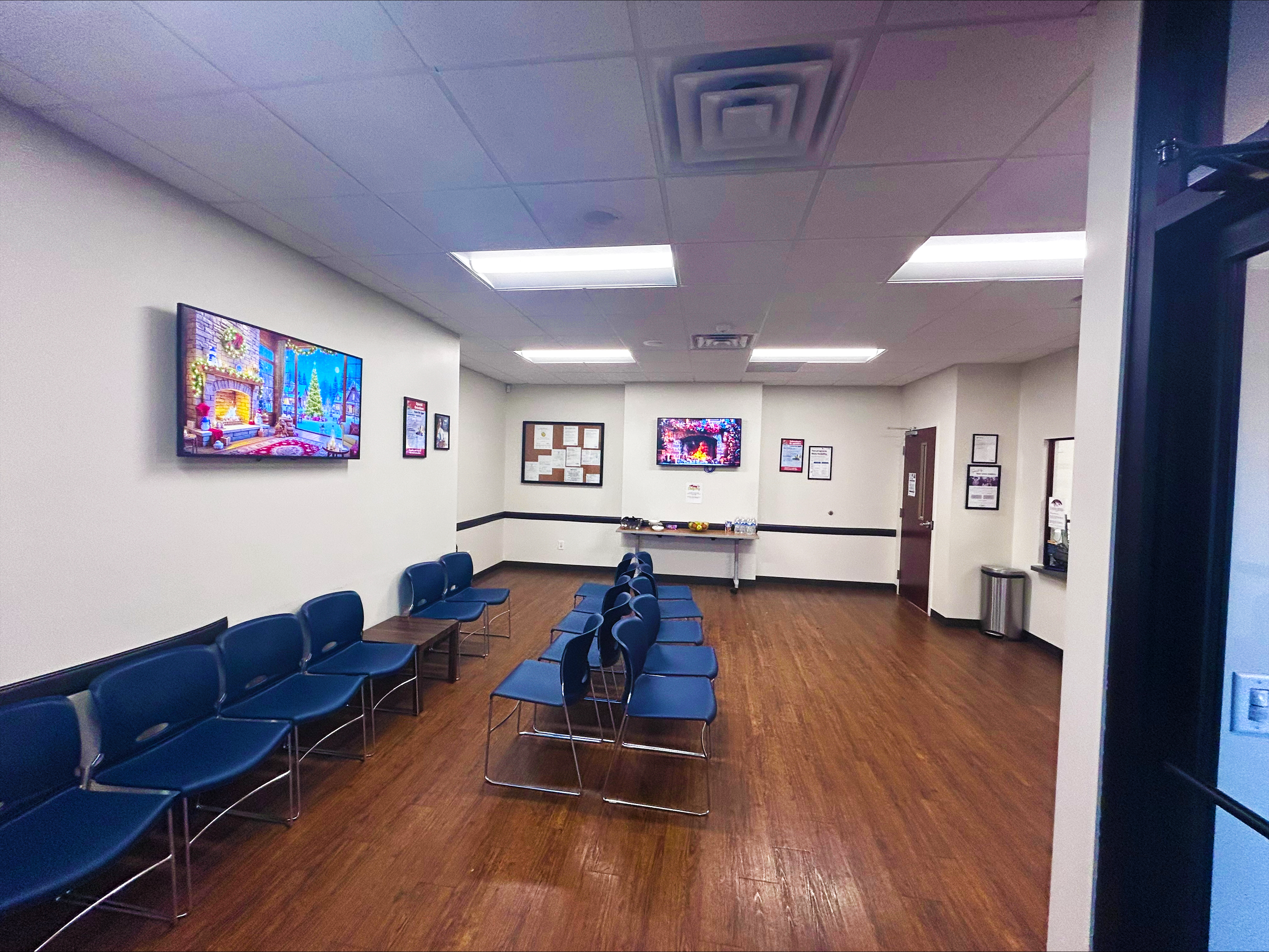 Spacious waiting room with seating and televisions
