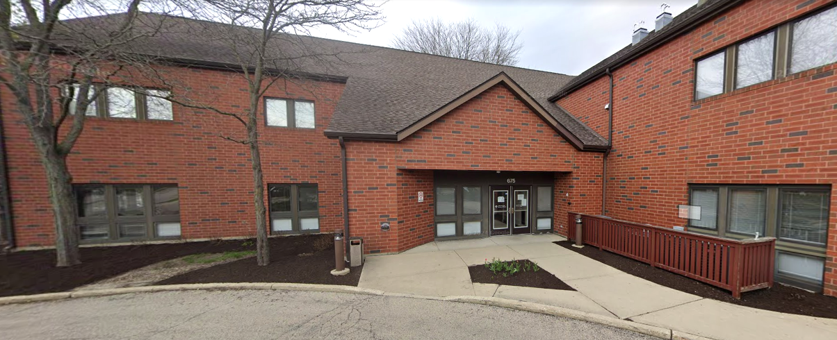 Red-brick rehab building with sidewalk and railing