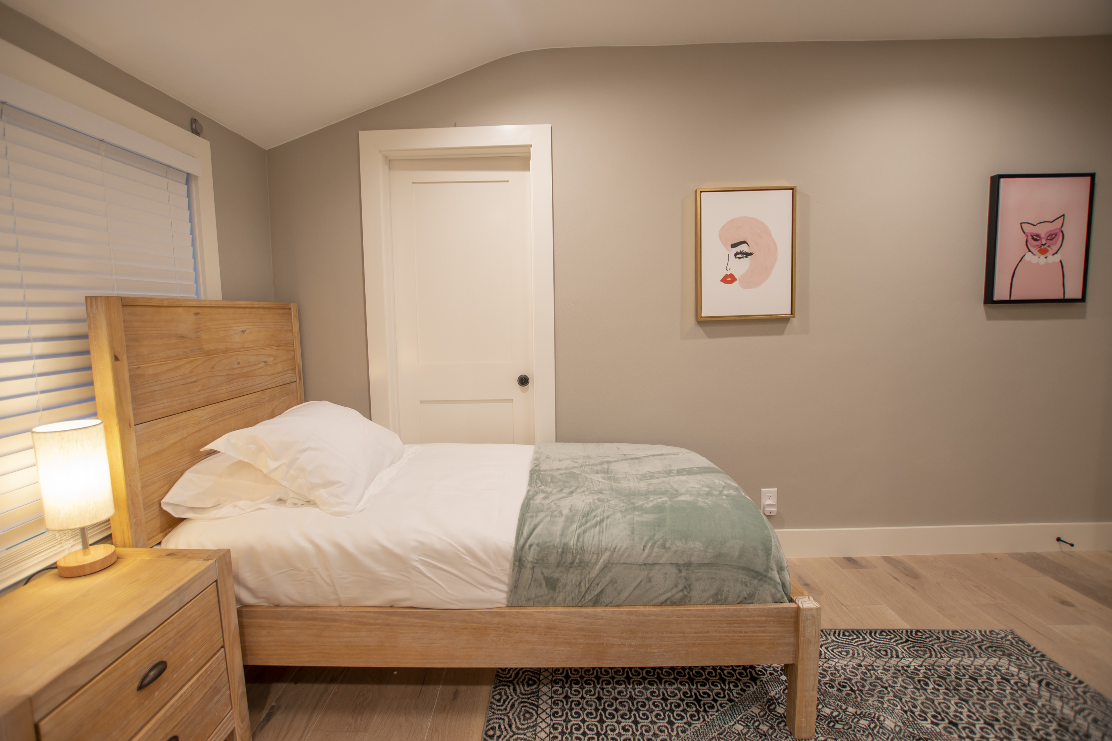 Single bed with minimal art and soft lighting