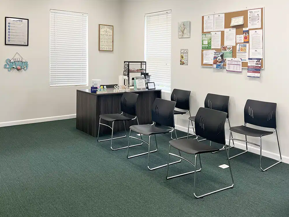 Waiting area with chairs and bulletin board on wall