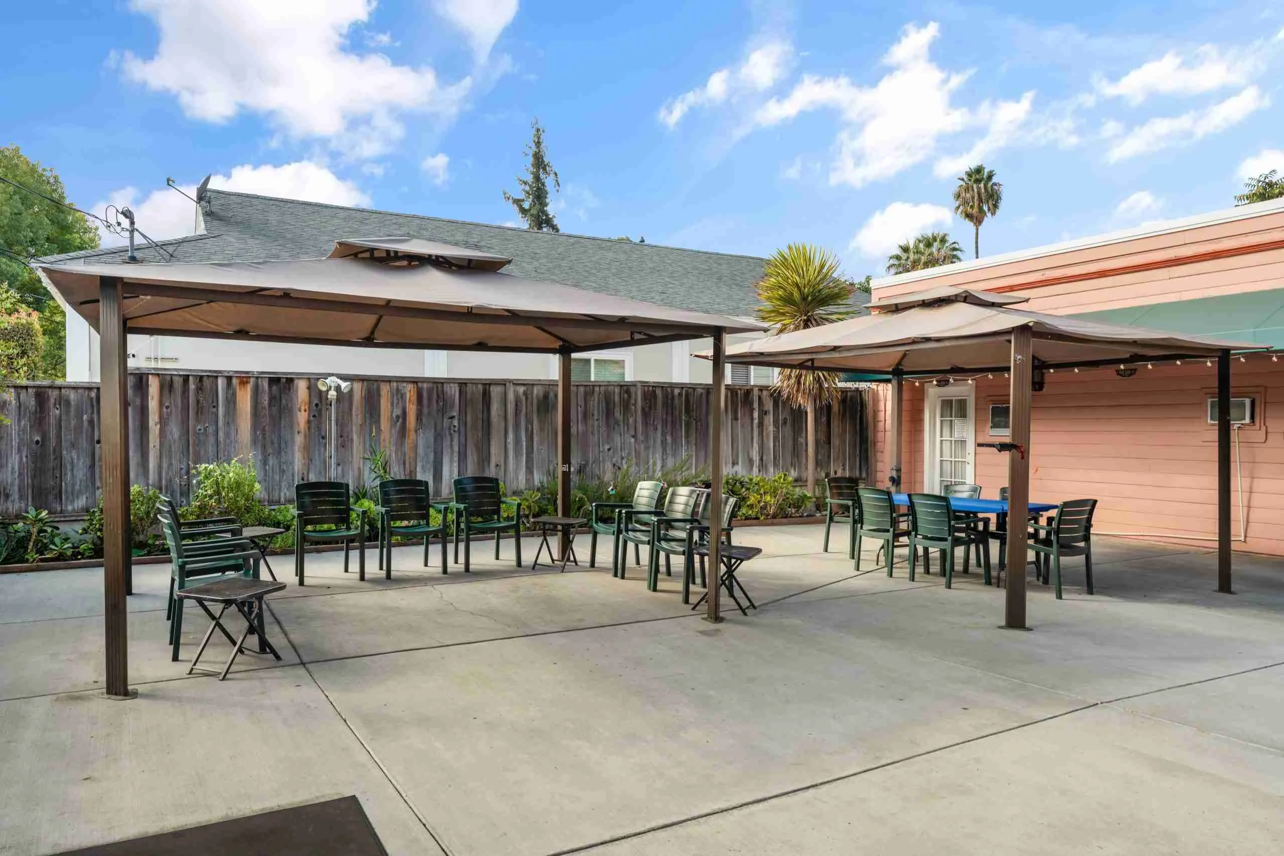 Outdoor seating area with tables and shade canopy.
