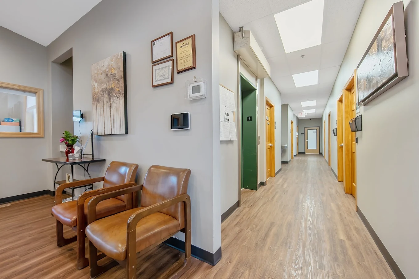 Hallway with leather chairs and framed certificates on the wall