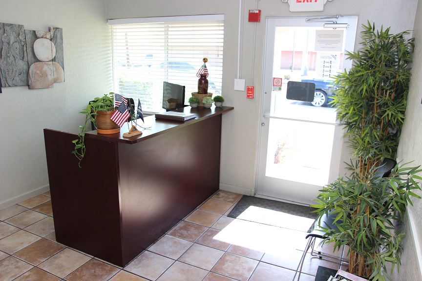 Reception area with desk, chairs, and indoor plants