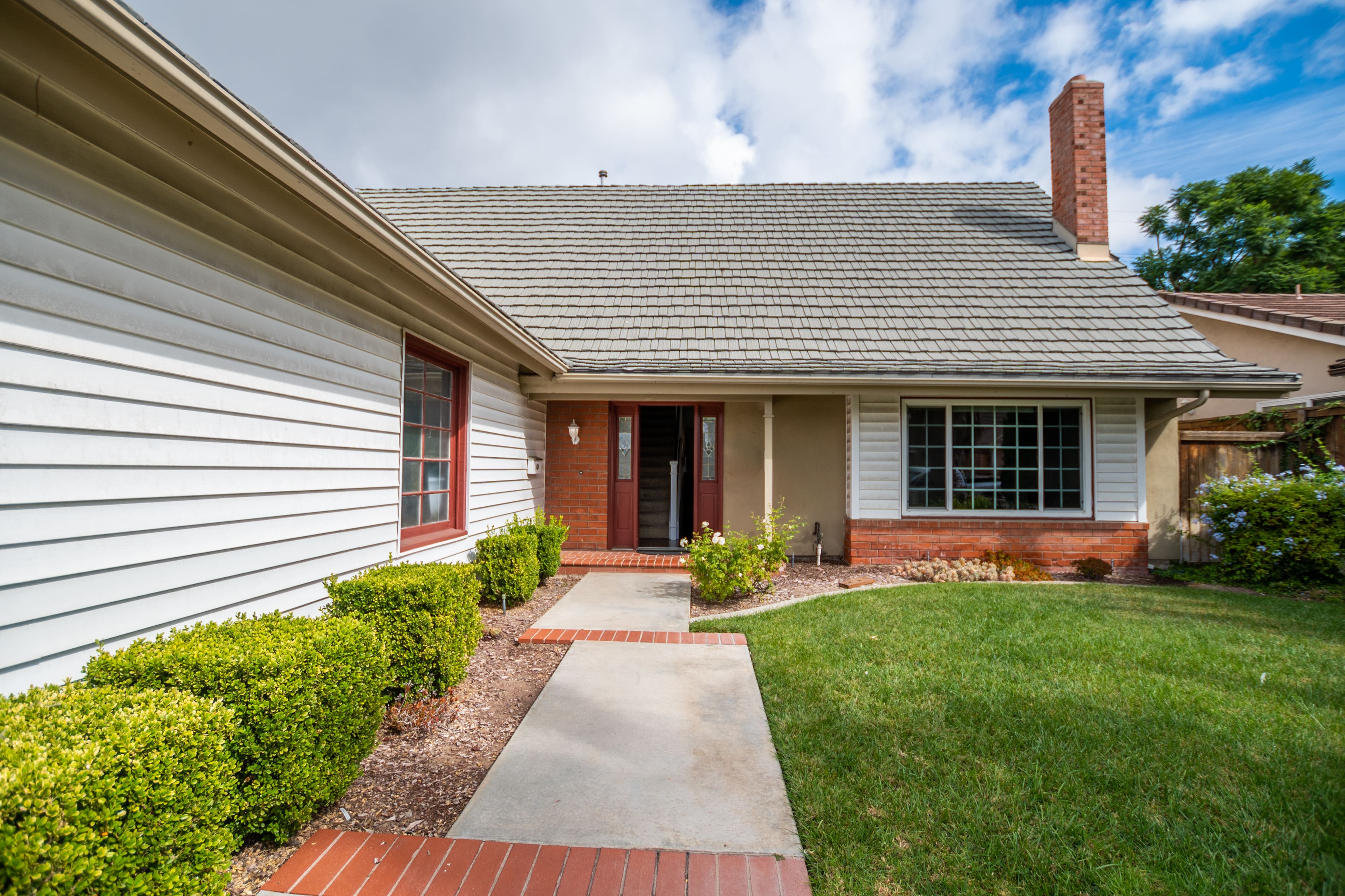 Brick and siding home with manicured front lawn