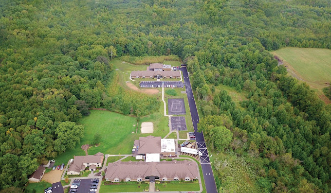 Forested facility with buildings, fields, and roads
