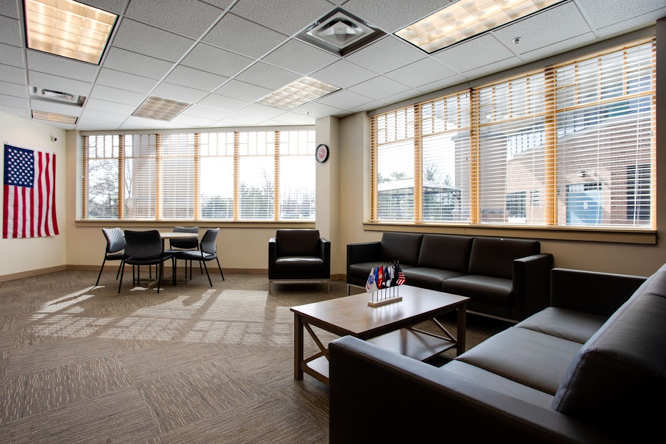 Lounge with sofas, table, and American flag on wall
