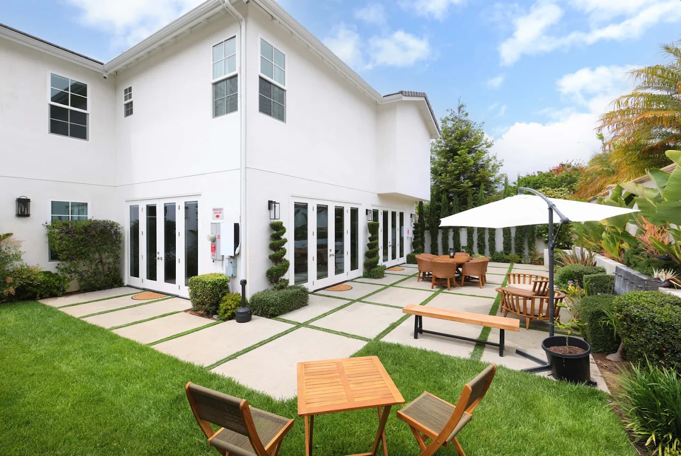 Landscaped courtyard with tables, chairs, and umbrellas