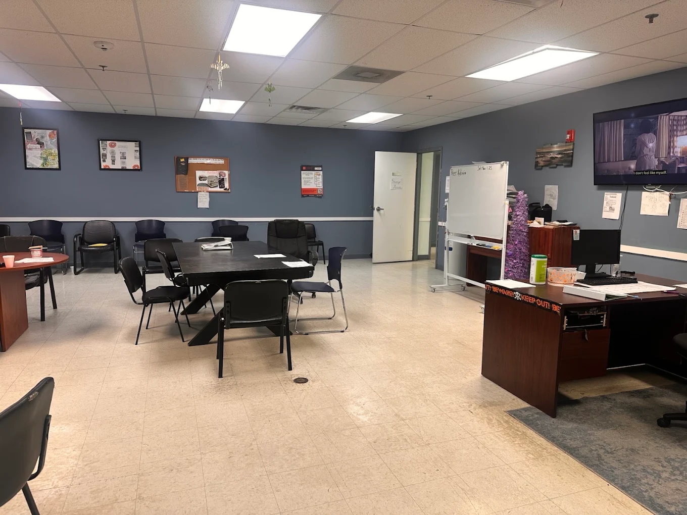 Group room with tables, chairs, whiteboard, and television