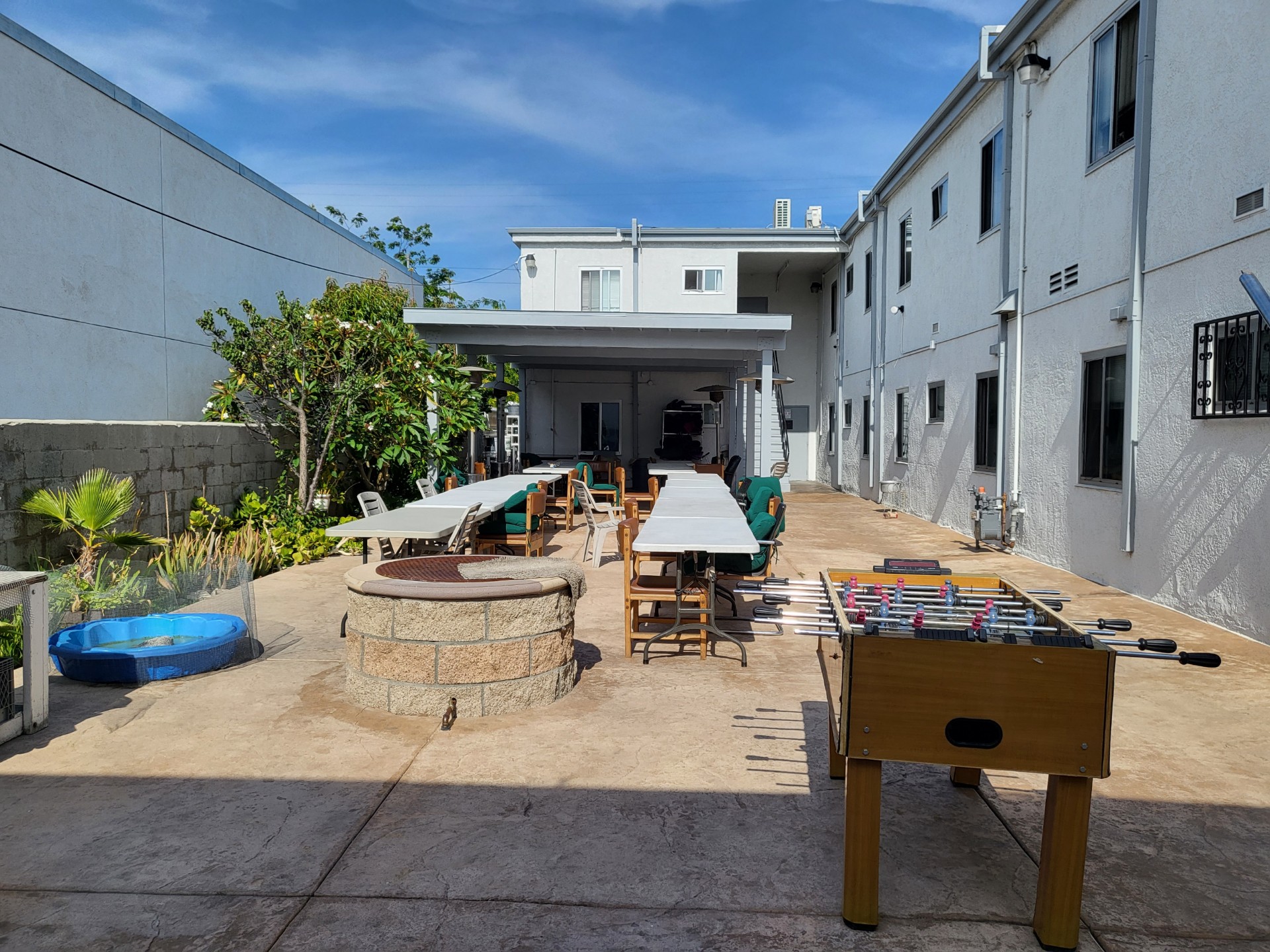 Courtyard with tables, foosball table, and plants at a Los Angeles rehab facility
