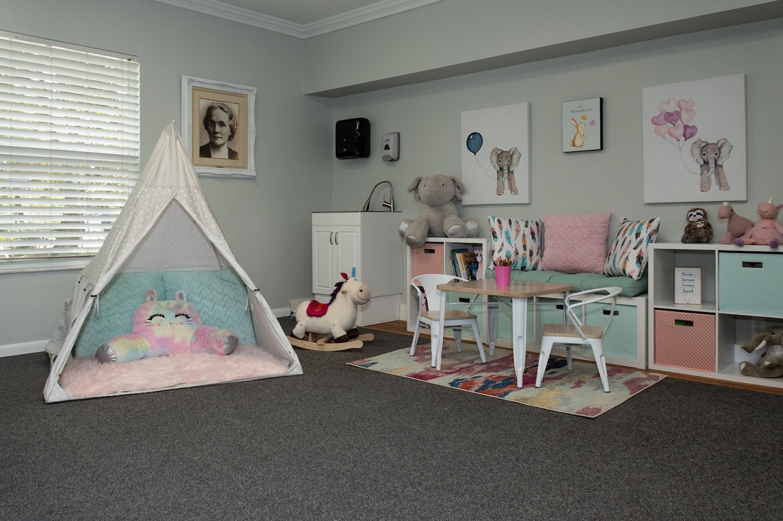 Playroom with tent, toys, and child-sized furniture