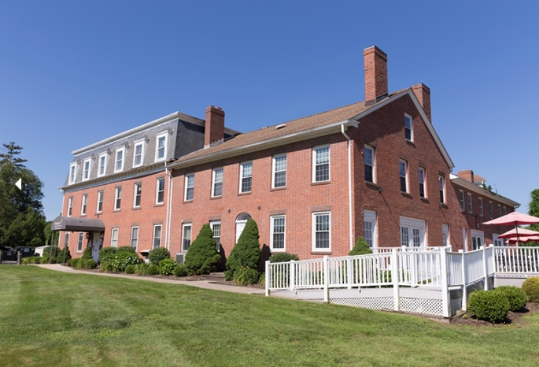 Red brick building with white trim and green lawn