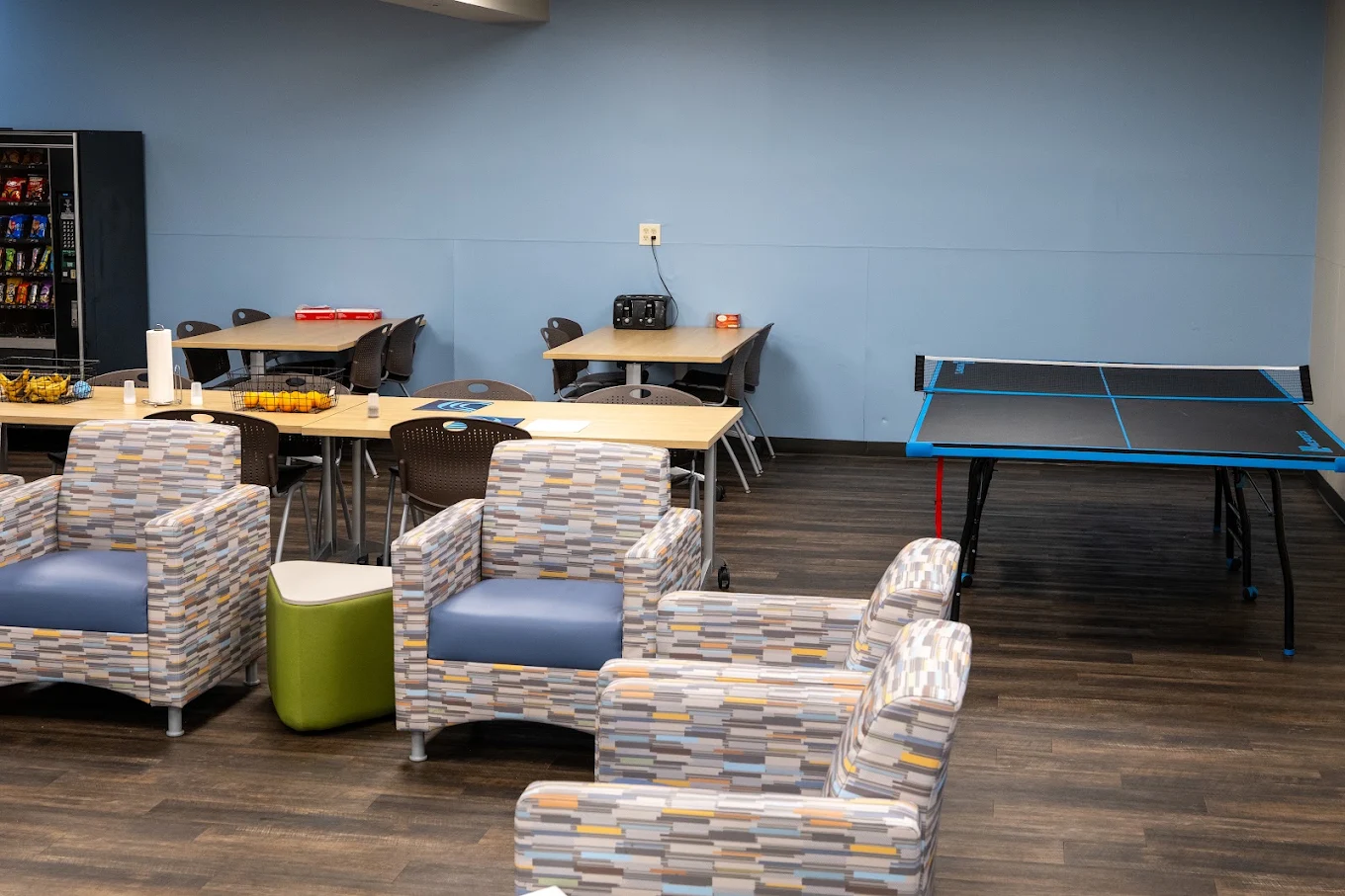 Lounge with armchairs, dining tables, and ping-pong table