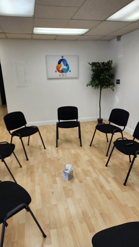 Group therapy room with black chairs in a circle.