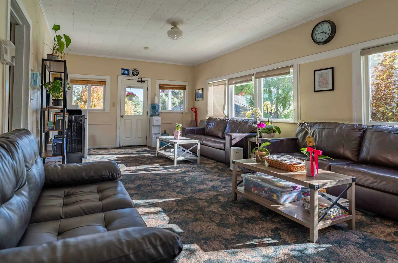 Cozy living room with leather sofas, tables, and large windows