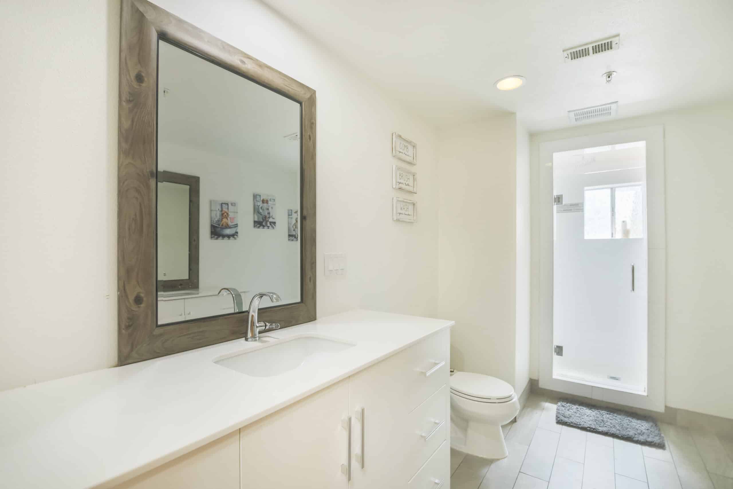 Bright bathroom with large mirror and walk-in shower