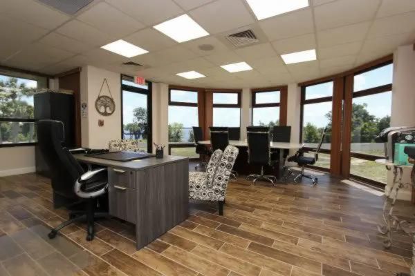 Office space with large windows and desks.