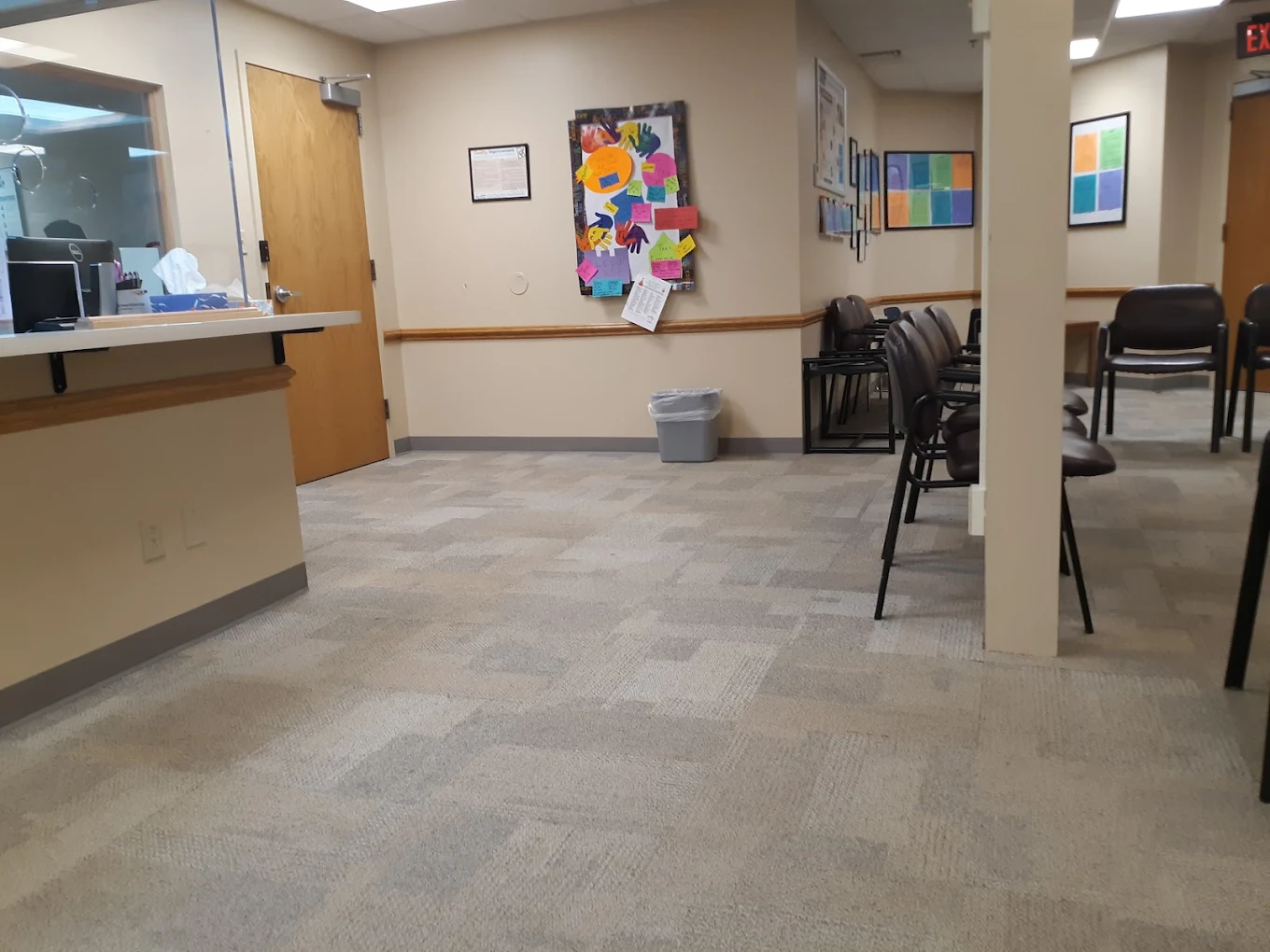Reception desk with chairs and bulletin board in waiting area