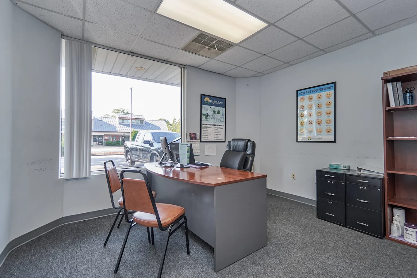 Consultation room with desk, computer, and visitor chairs