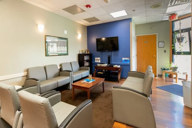 Comfortable lounge with gray chairs and TV on blue accent wall