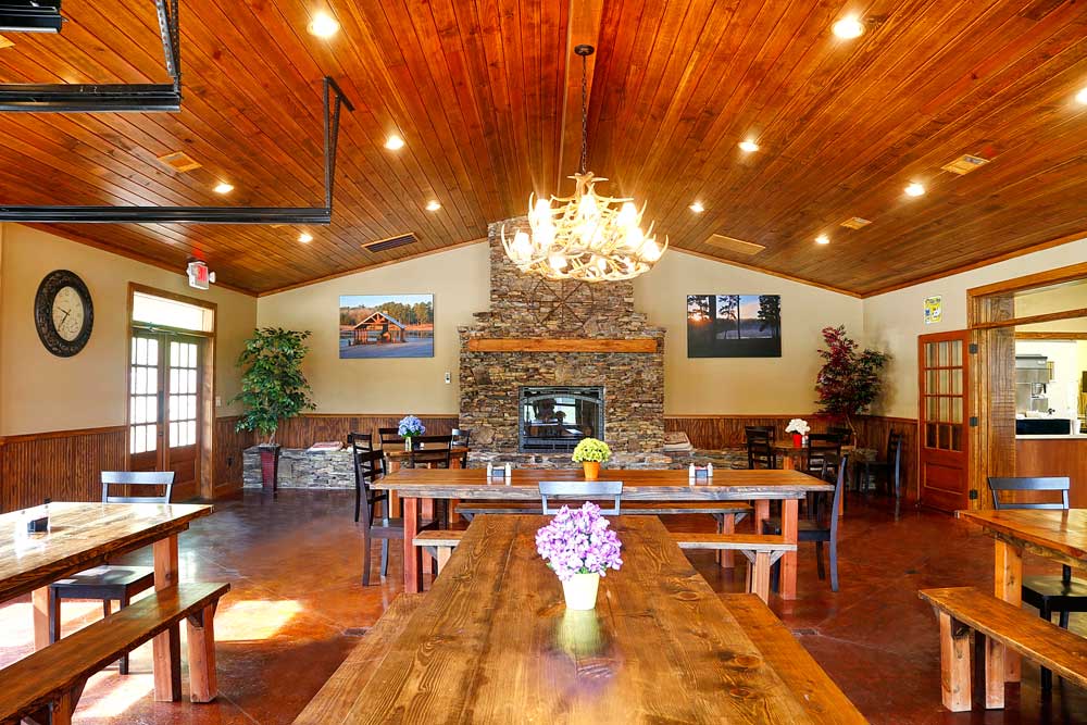 Rustic dining area with wooden tables and stone fireplace