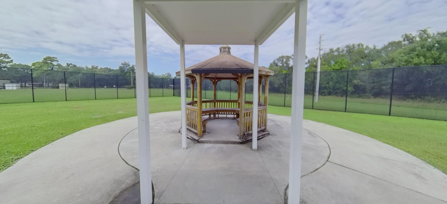 Wooden gazebo in a landscaped outdoor courtyard