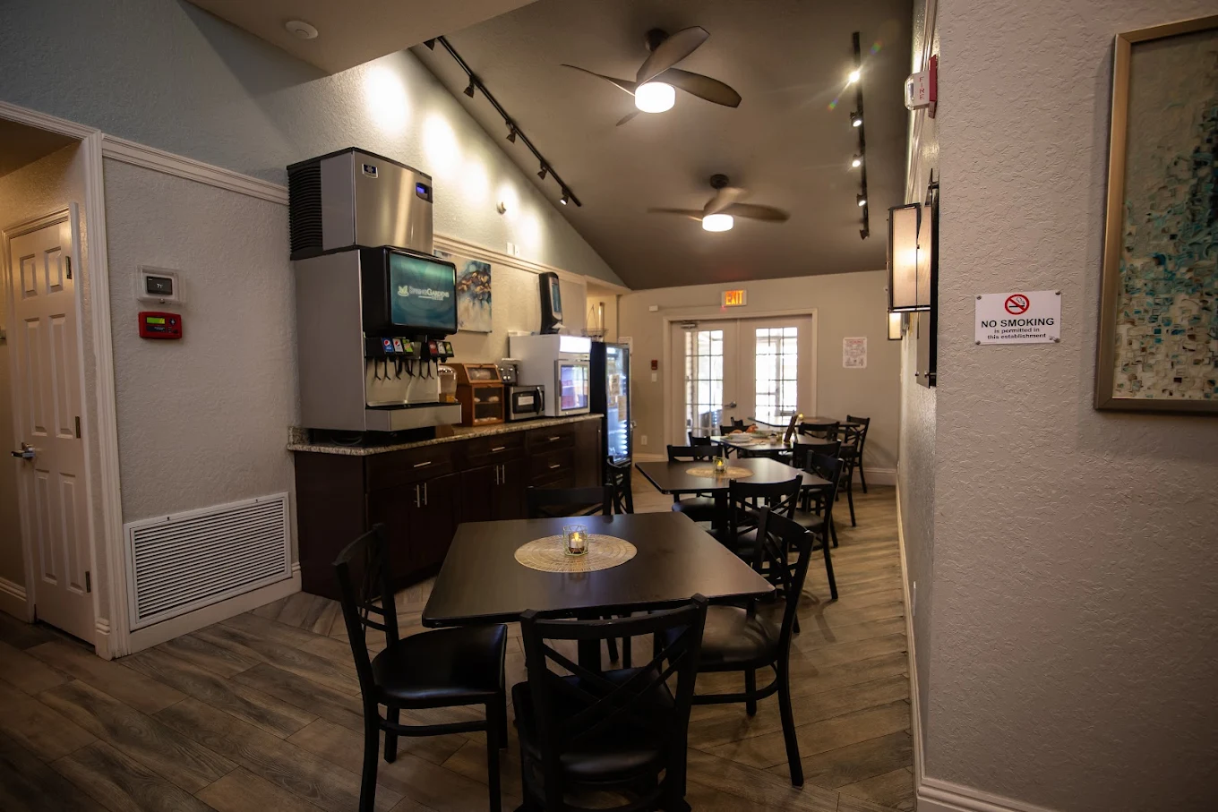 Cafeteria with tables, drink machine, and natural light