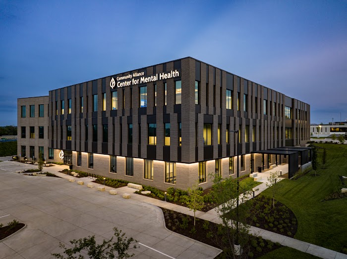 Modern building with tall windows and parking lot
