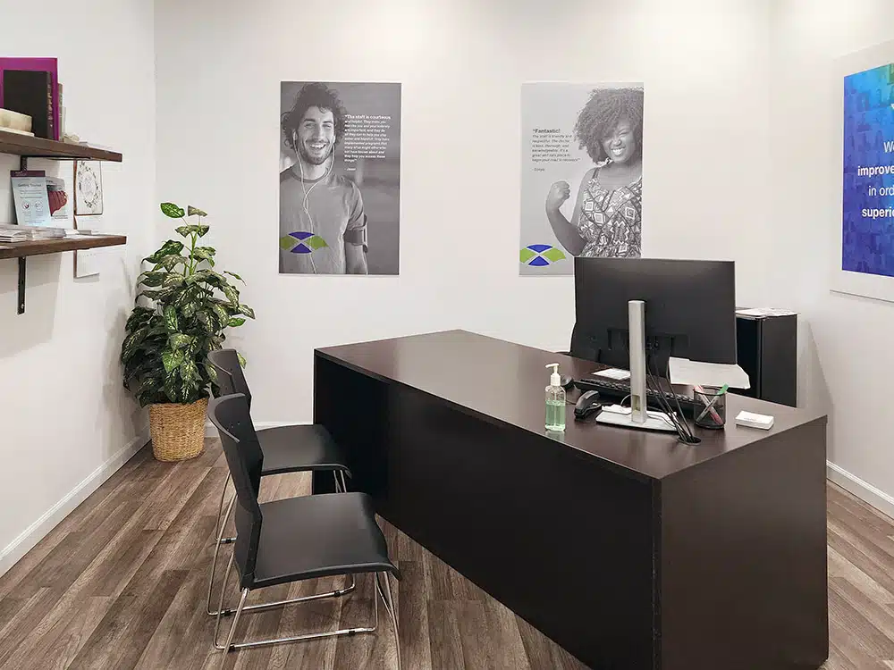 Office with desk, chairs, and patient posters on wall