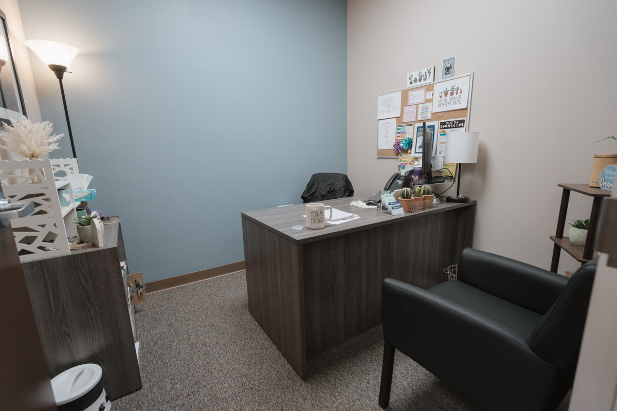 Counseling office with desk, guest chair, and bulletin board
