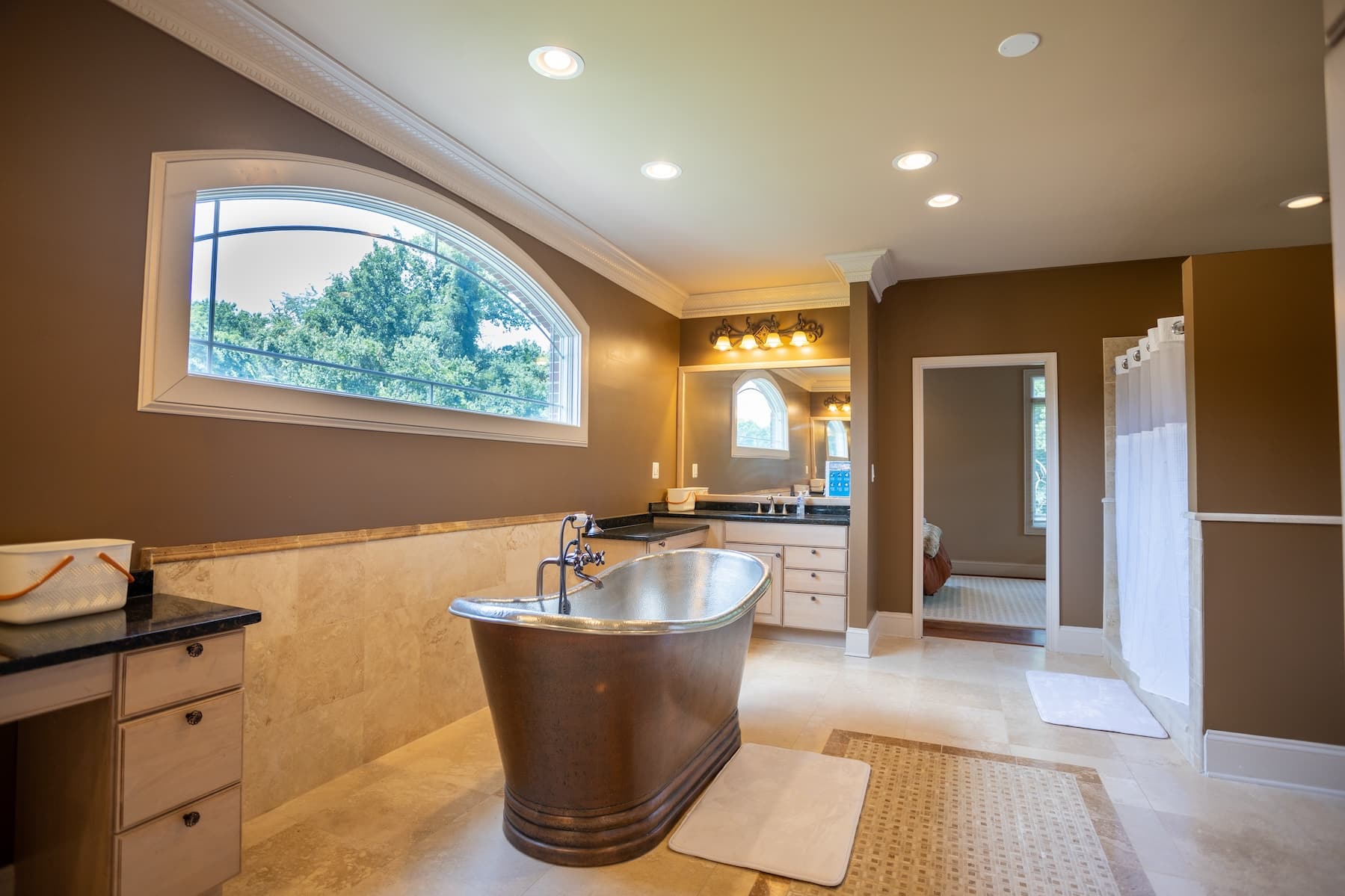A spacious bathroom with a soaking tub and a large window