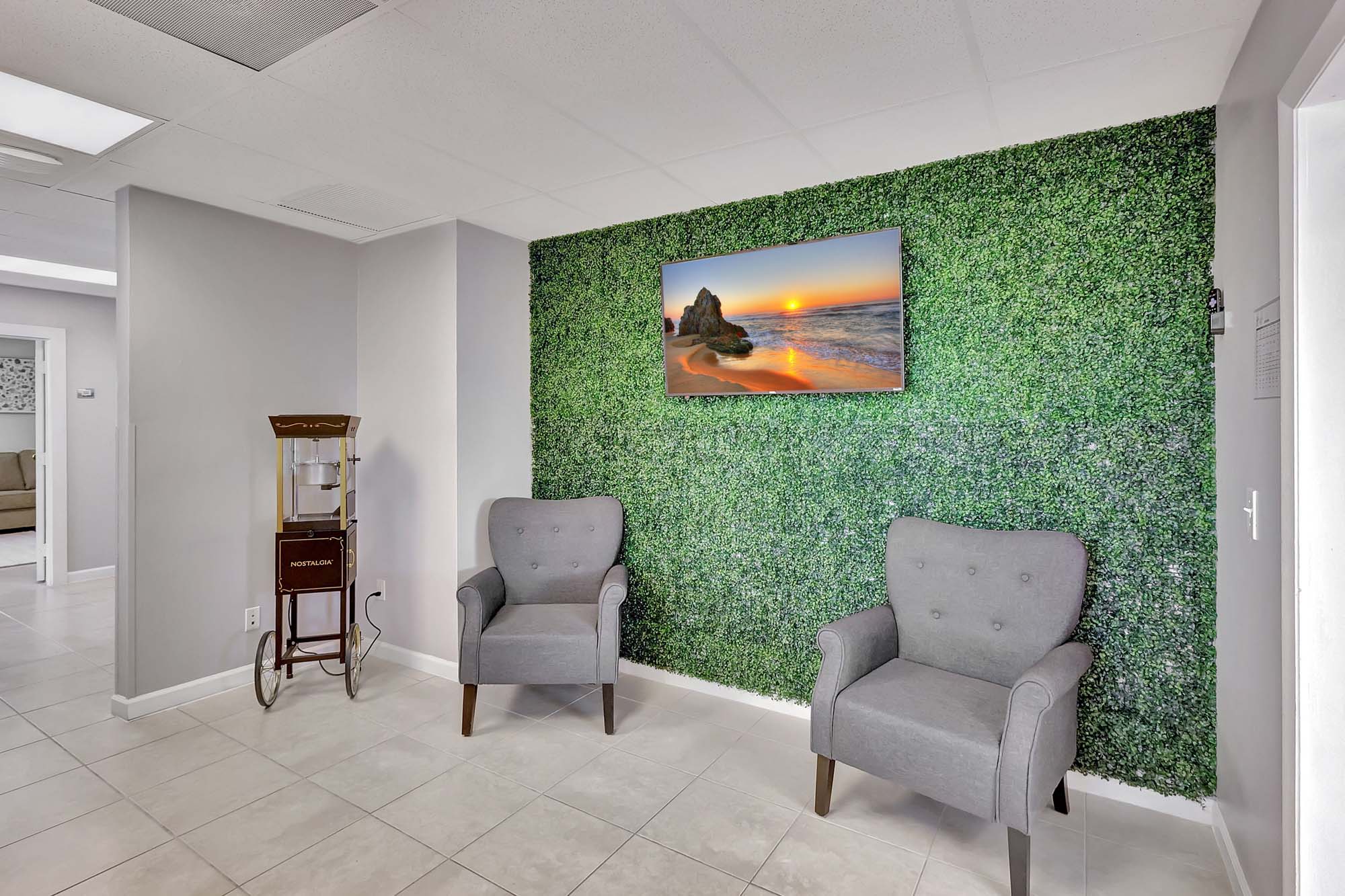 Waiting area with armchairs and green wall décor