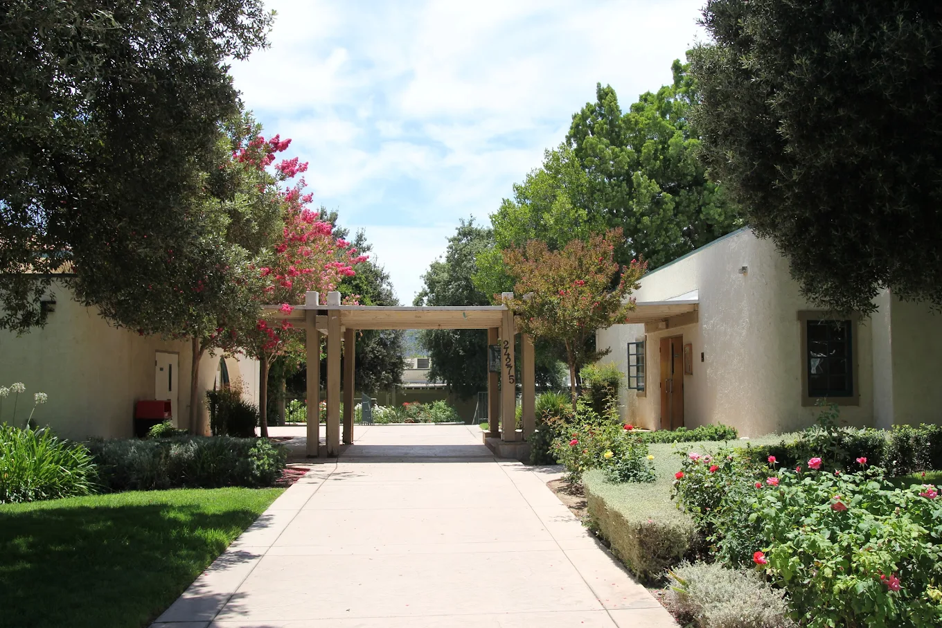 Landscaped campus entrance with shaded walkway and gardens