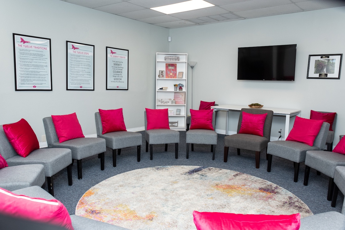 Circle of chairs with pink pillows in bright meeting room