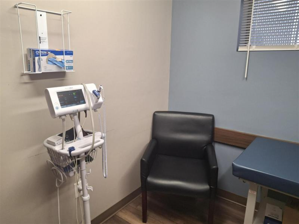 BrightView Health Batavia consultation room with vital signs monitor, patient chair, and exam table