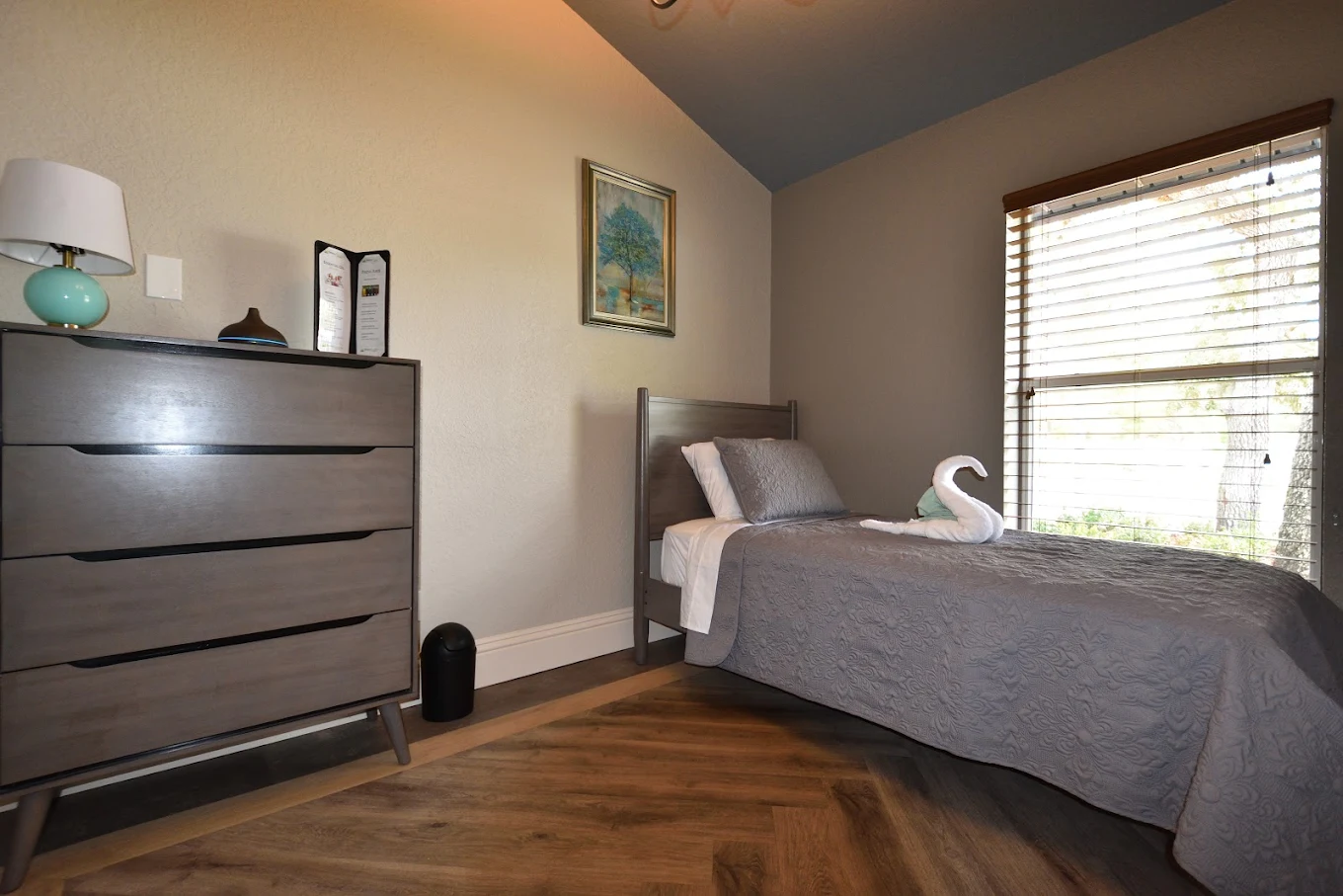 Neat single bed by window in cozy bedroom