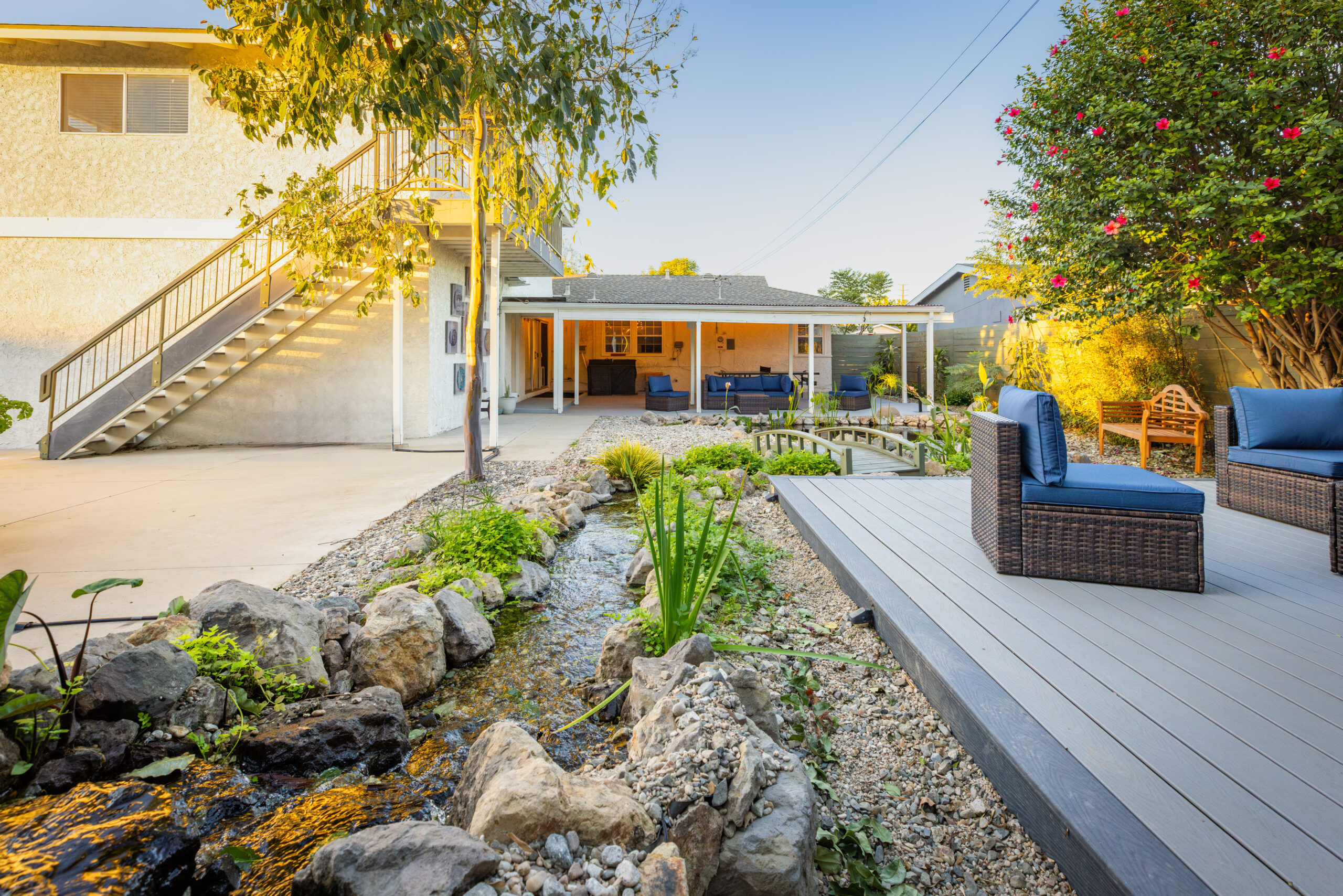 Garden area with chairs, flowers, and decorative bridge