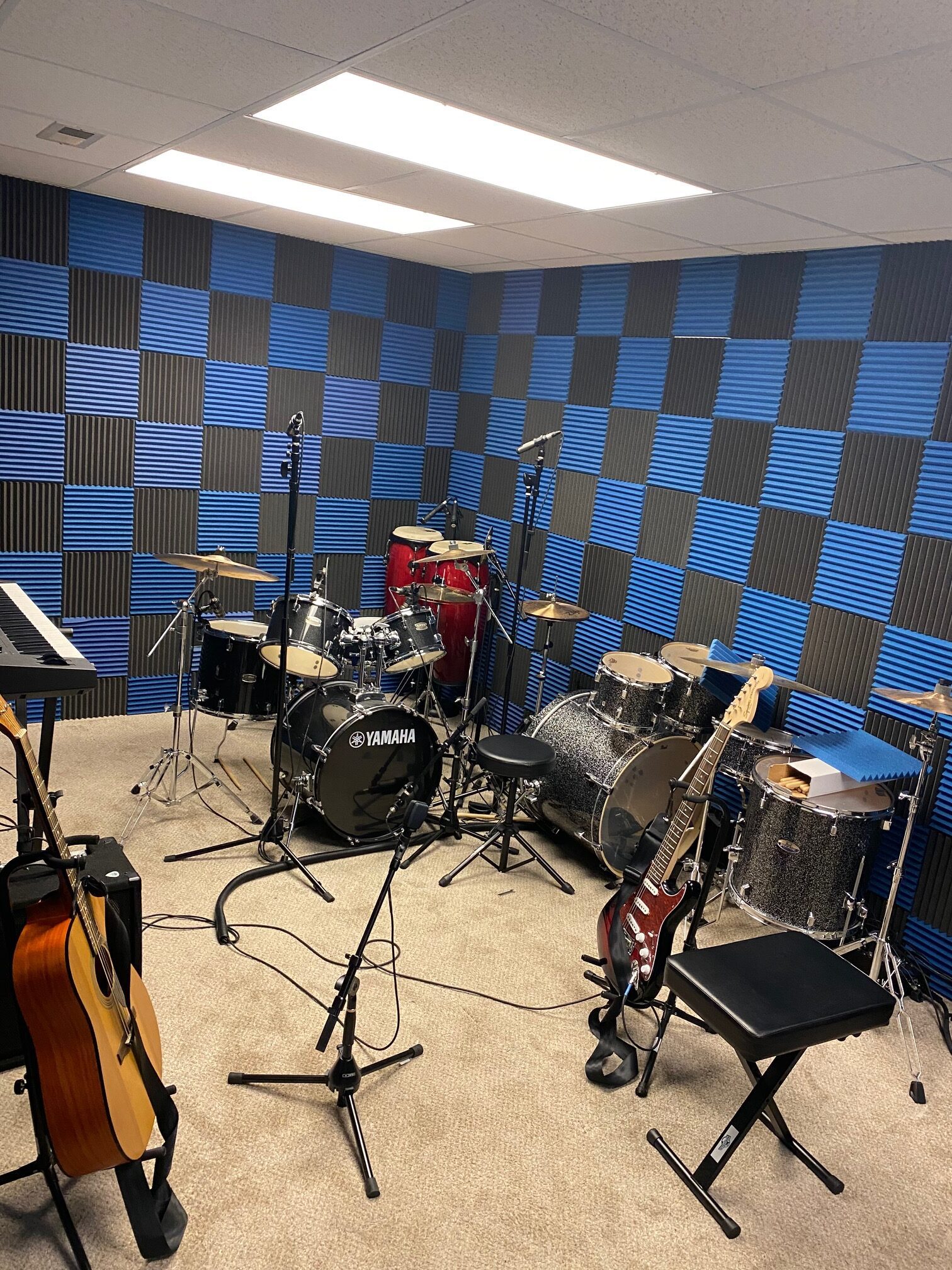 Soundproofed music room with drums, guitars, and keyboard