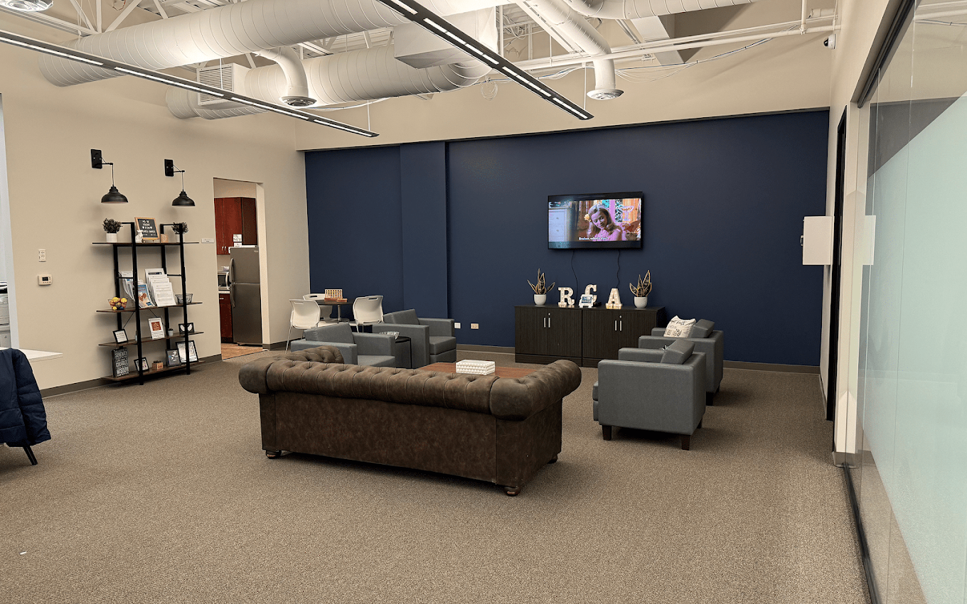 Spacious lounge with sofas, armchairs, TV, and open shelving