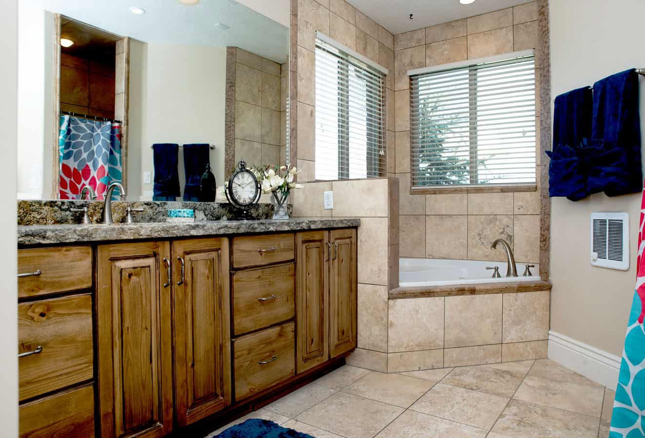 Spacious bathroom with double sinks and tiled soaking tub.