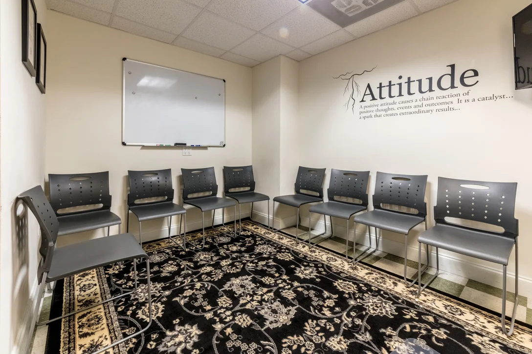 Circle of chairs with whiteboard in carpeted meeting space