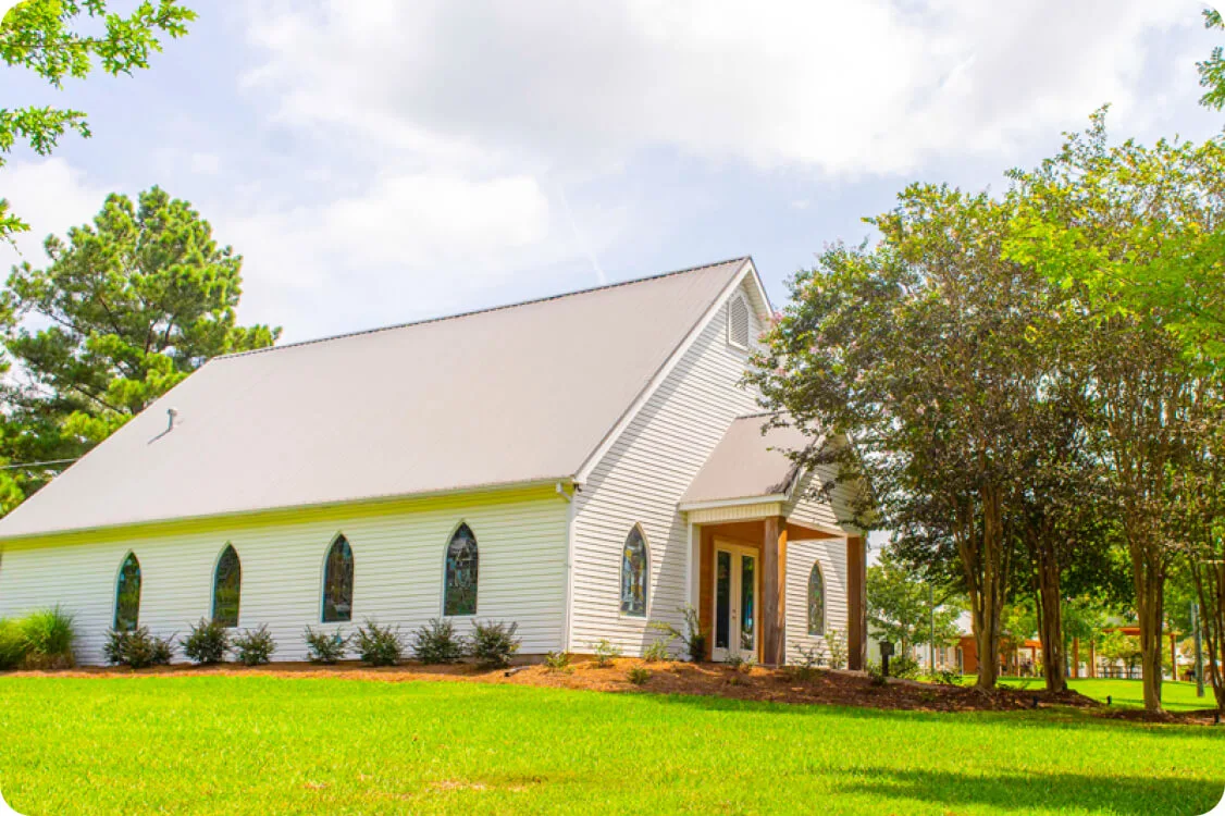 White chapel under sunny skies and trees