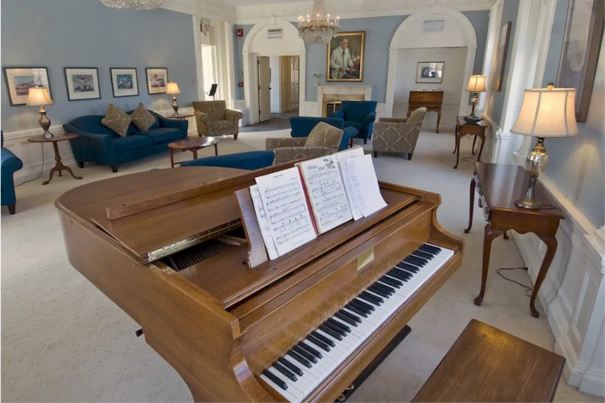Grand piano in an elegant lounge with comfortable seating.