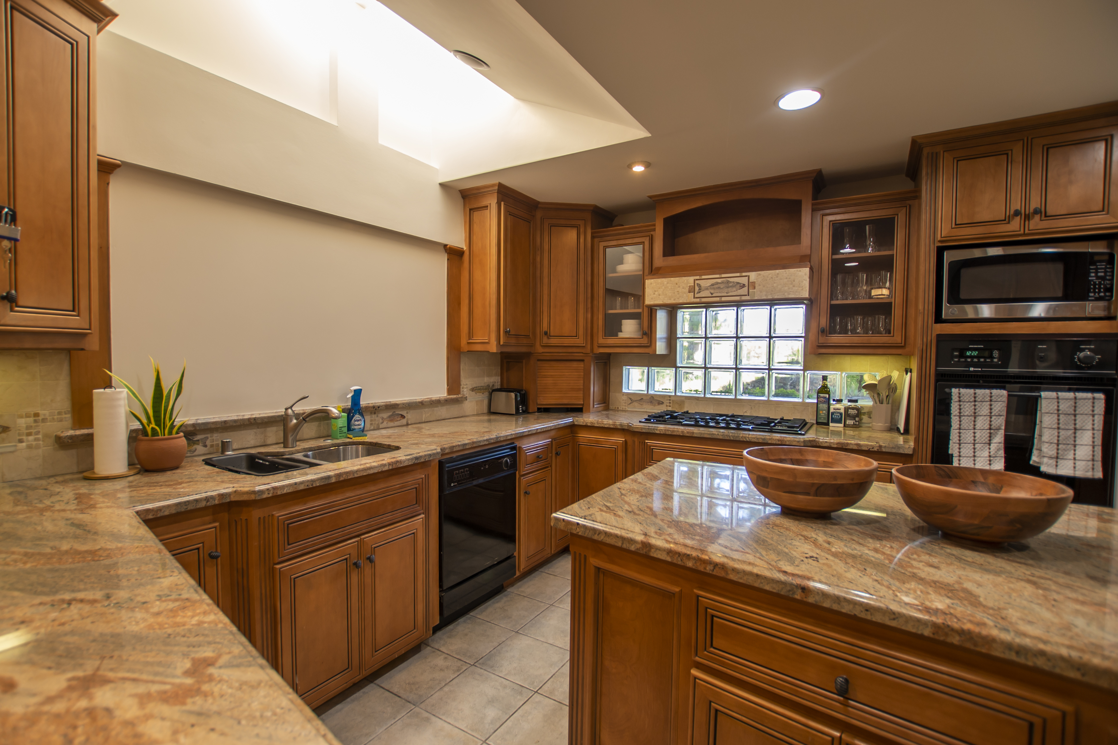 Kitchen with island, skylight, and wood cabinets
