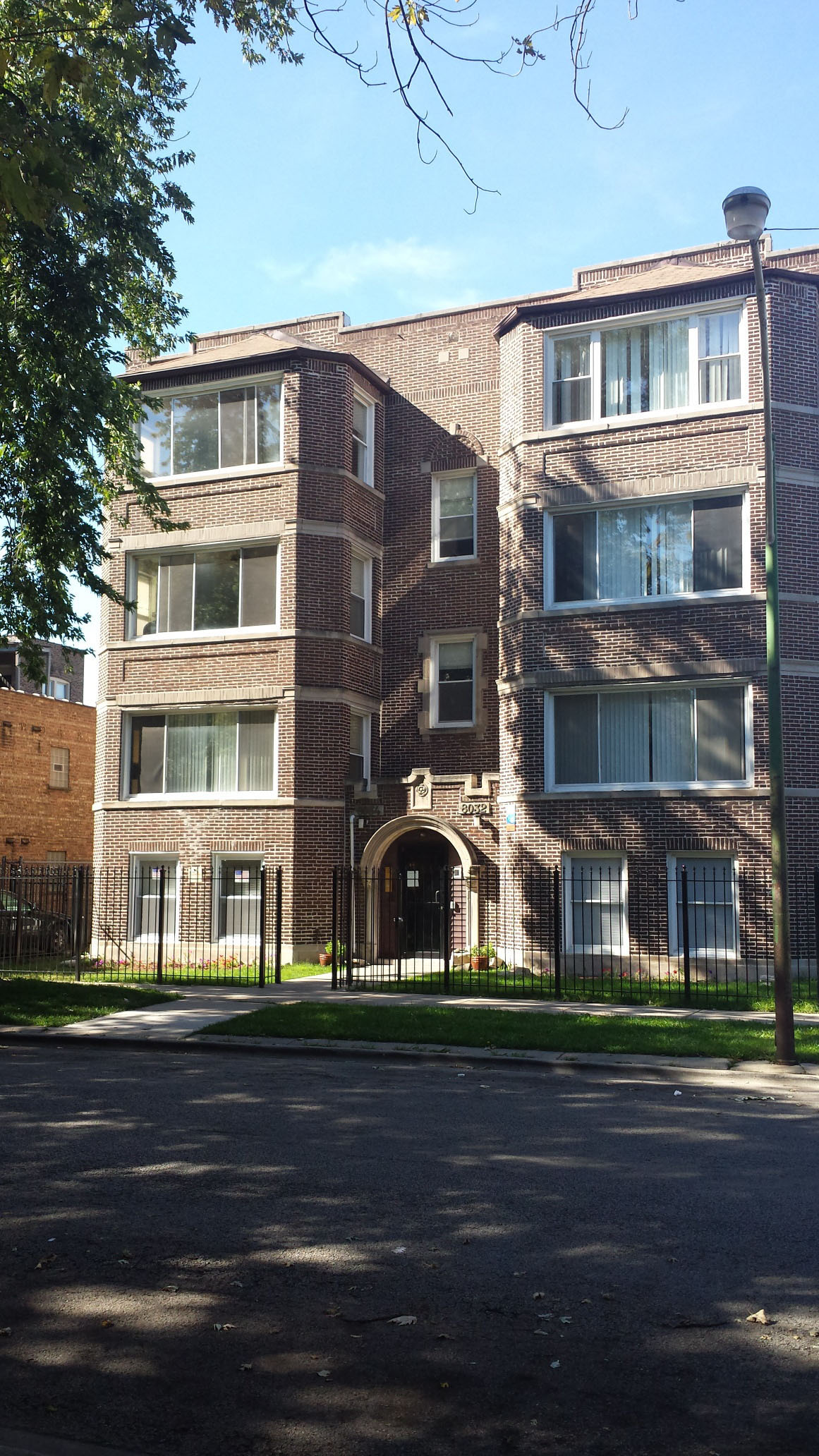 Exterior of brick apartment building with gated entry