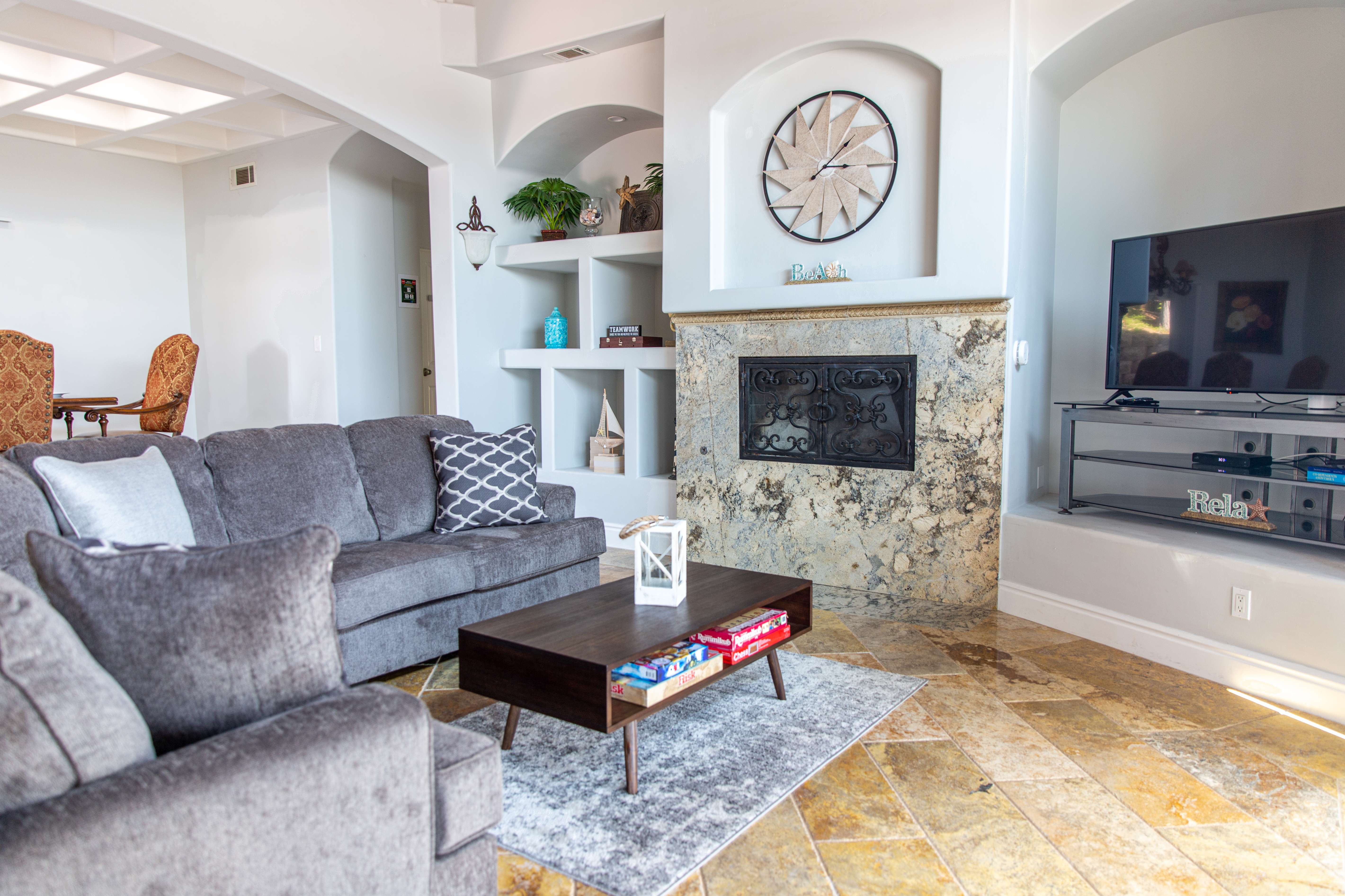 Cozy living area with gray sofas, TV, and stone fireplace