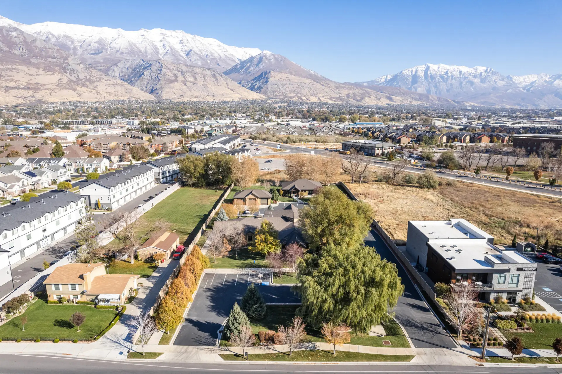 Aerial view of facility with mountain backdrop and nearby homes