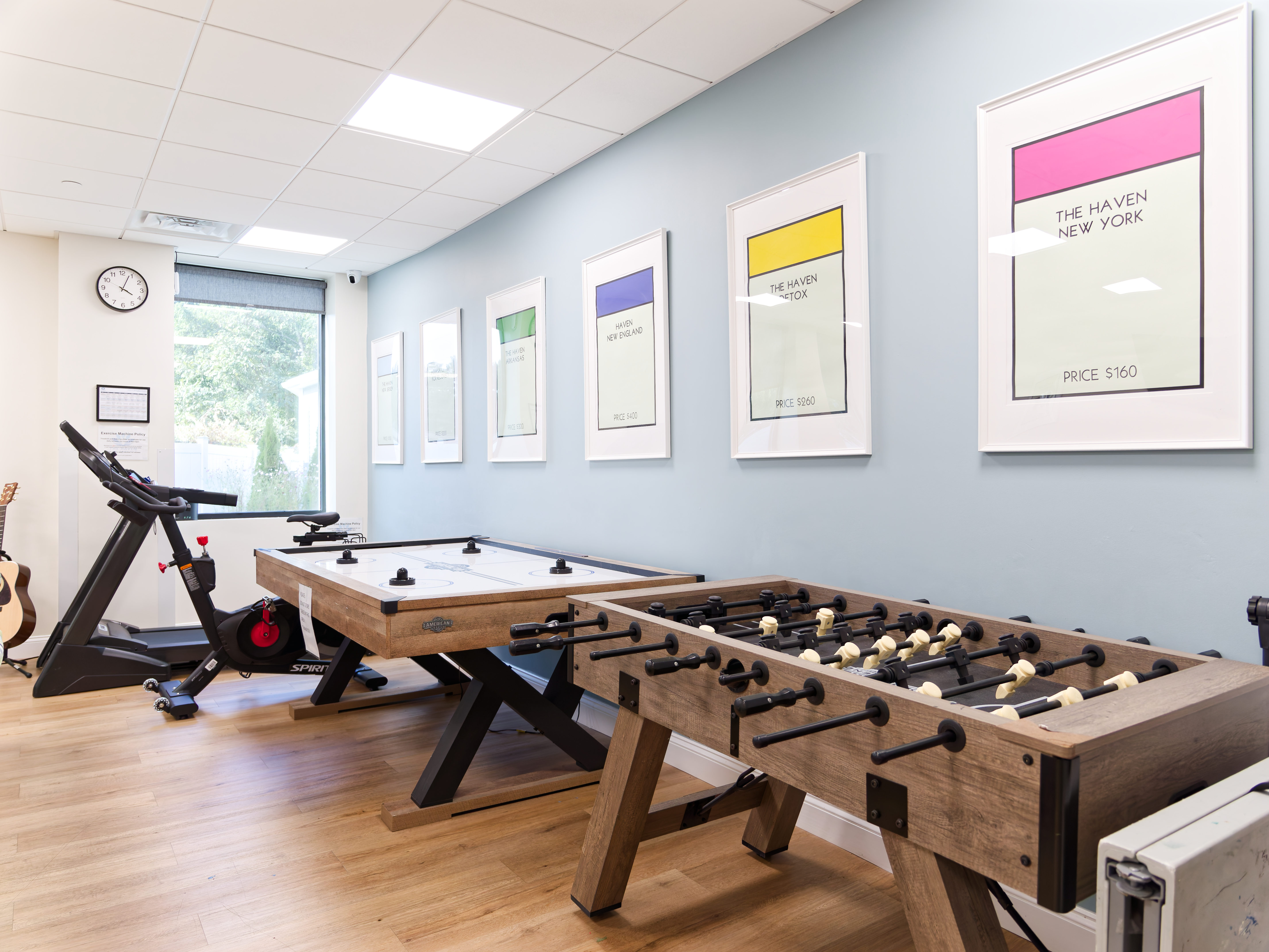 Room with foosball, air hockey, and fitness equipment.