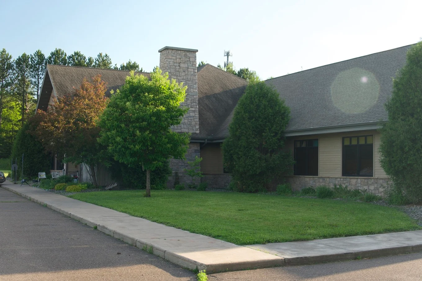 Front view of Pioneer Recovery Center surrounded by green grass and trees in summer
